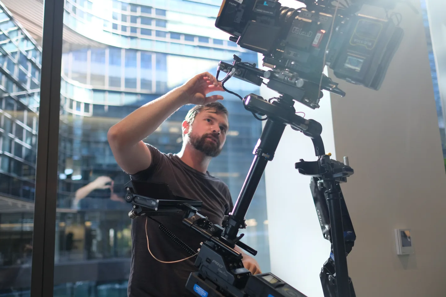 Nick Schwyter adjusting a Steadicam-mounted RED camera on location.