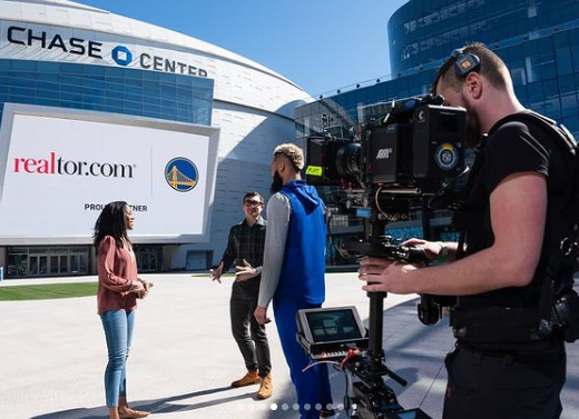 Camera operator filming Realtor.com talent outside Chase Center in San Francisco.