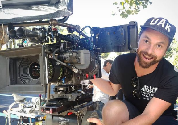 Nick Schwyter beside a cinema camera during a Tom Steyer production.